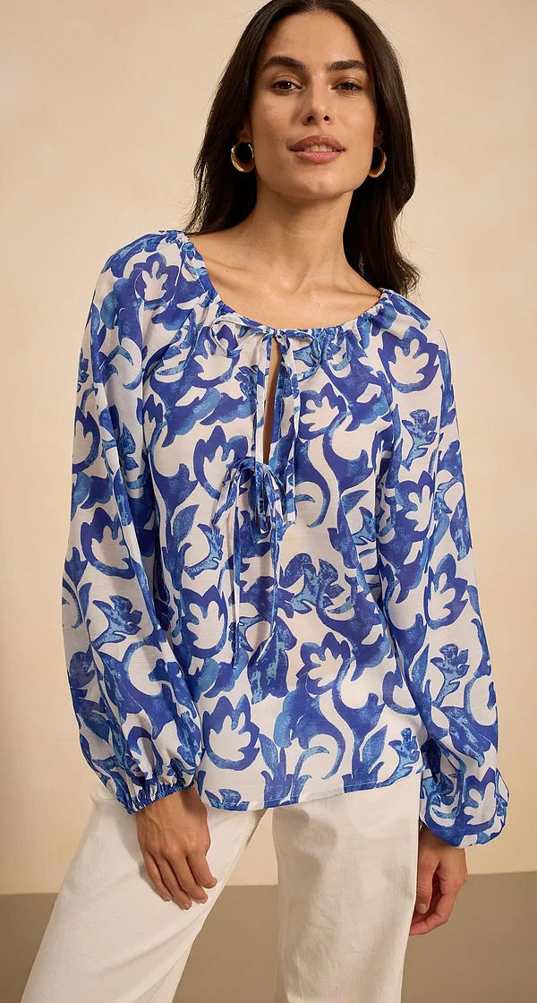 Blouse légère à manches longues et motif floral dans des tons bleu et blanc.