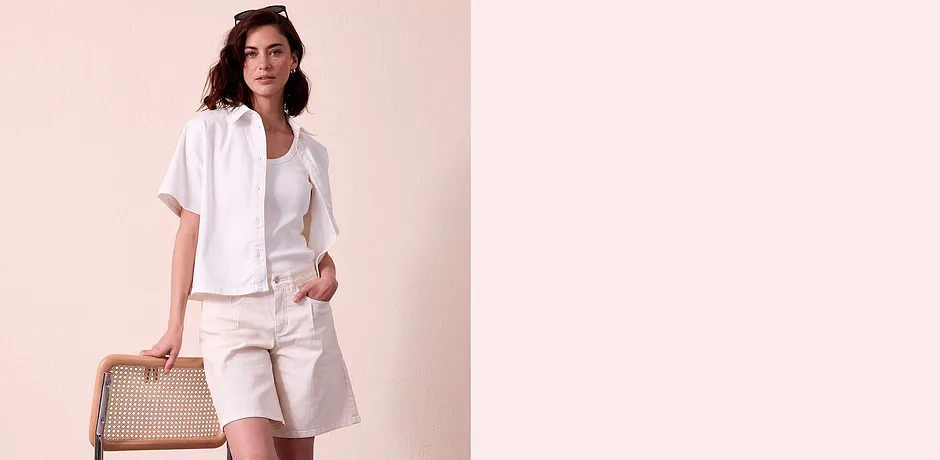 Tenue estivale élégante en blanc : chemisier à manches courtes, T-shirt et bermuda avec poches.
