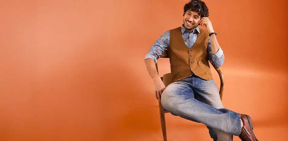 L'association tendance : jean, chemise à motifs et gilet marron sans manches.