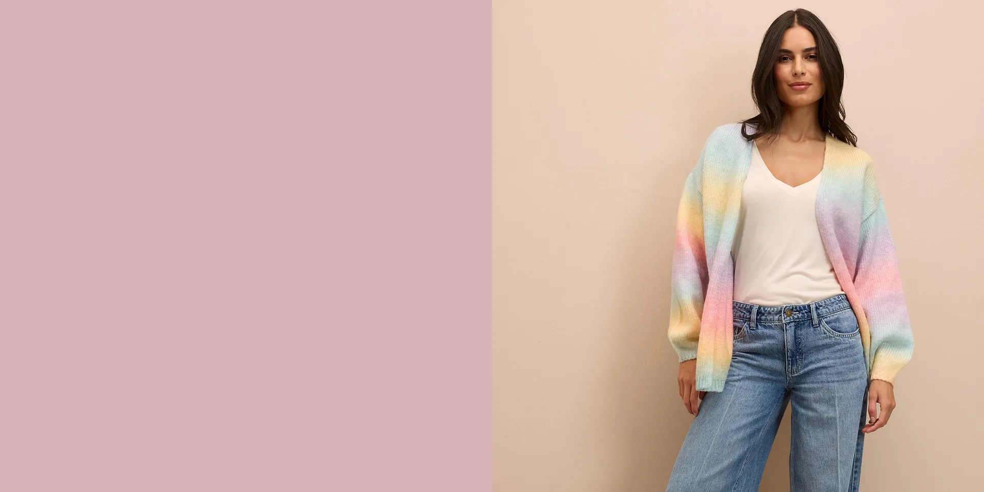 Gilet en maille en couleurs pastel sur un top blanc, associé à un jean large pour un look décontracté.