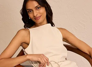 Robe crème élégante à col haut dotée d'une ceinture qui souligne et affine la silhouette.