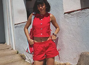 Ensemble rouge flamboyant pour l'été : gilet sans manches boutonné et petit short. Tenue légère et stylée.