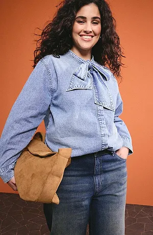 Chemisier en jean bleu clair avec lavallière, jean foncé et sac marron pour un look décontracté au quotidien.