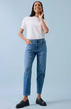 Look décontracté composé d'un T-shirt blanc, un jean bleu et des chaussures noires.