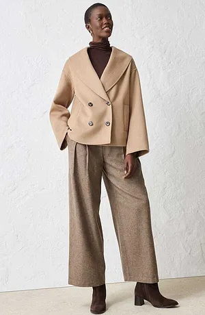 Veste avec laine de couleur beige, pull à col roulé marron et pantalon large.