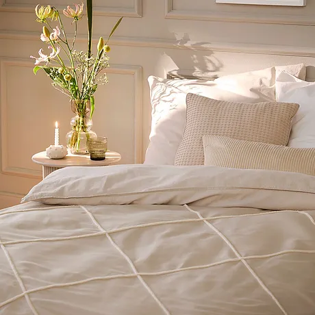 Une parure de lit claire et cosy à carreaux donne de la convivialité à votre chambre à coucher. La couette et les coussins sont en parfaite harmonie.