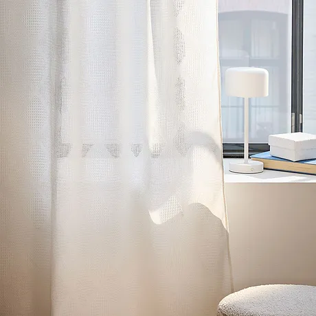 Les voilages blancs habillent vos fenêtres et filtrent légèrement la lumière du jour.