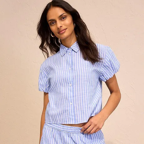Petit chemisier bleu clair rayé à manches courtes bouffantes et patte de boutonnage. Parfait pour créer une tenue estivale.