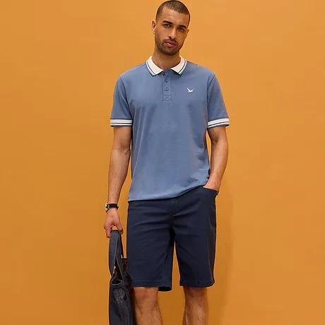 Polo bleu clair avec col blanc et pantalon foncé. Une tenue sportive et élégante pour tous les jours.