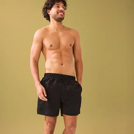 Short de bain noir qui souligne la silhouette athlétique.