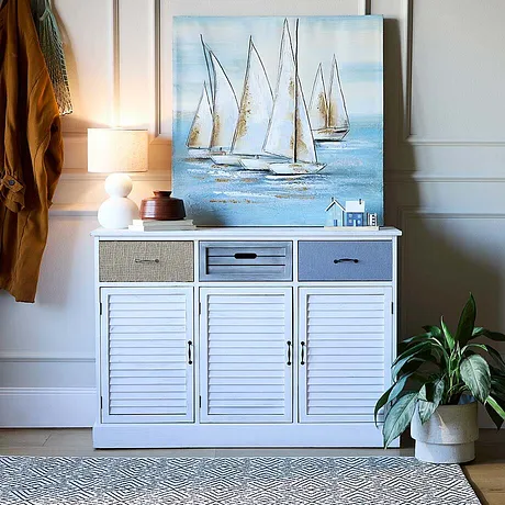 Un tableau marin posé sur une commode blanche, une ambiance douce et conviviale dans l'entrée.