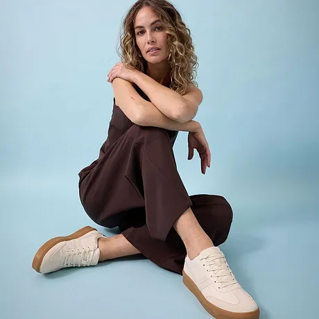 Combinaison marron associée à une paire de tennis couleur crème.