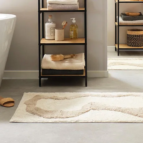 Des serviettes de toilette moelleuses et un tapis de bain douillet apportent du confort et de la douceur dans une salle de bain à l'ambiance élégante.