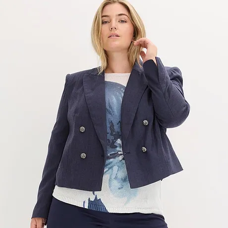 Blazer bleu marine par dessus un haut à motif.