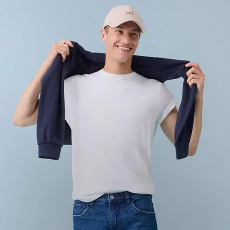T-shirt blanc, jean bleu & gilet foncé.