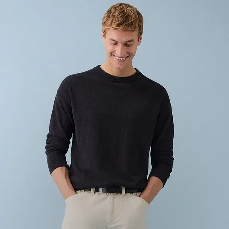 Pull noir élégant à col roulé associé à un pantalon en velours côtelé vert olive.