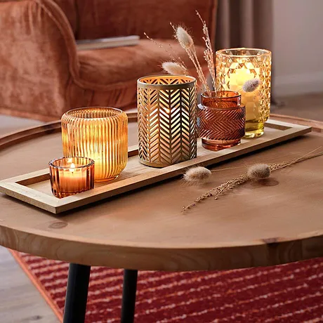 Ambiance cocooning d'automne avec des lumières chaudes. La texture veloutée du fauteuil invite à des moments de détente.