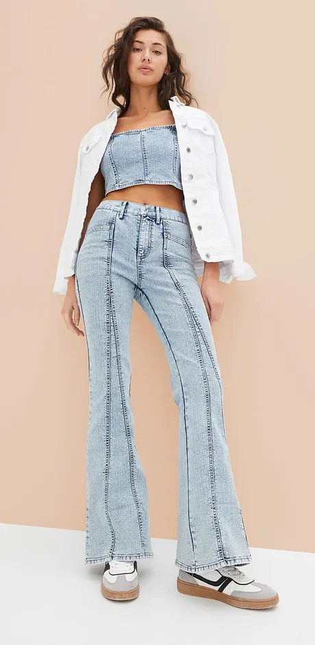 Tenue stylée avec veste en jean blanche, crop top et jean évasé dans un style rétro.