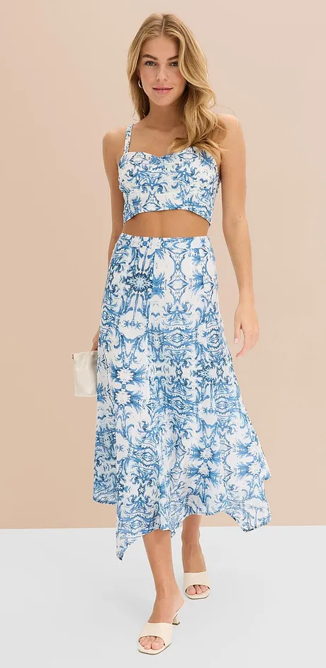Tenue estivale 2 pièces à motif floral bleu et blanc : crop top et jupe longue asymétrique à la base.