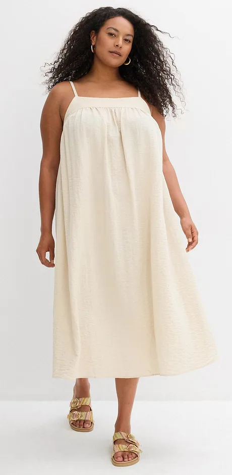 Robe d’été à bretelles de couleur crème avec une coupe décontractée. 