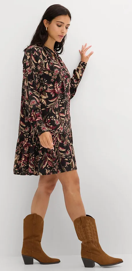 Robe noire à motif floral, portée avec une paire de bottes de cowboy marron.