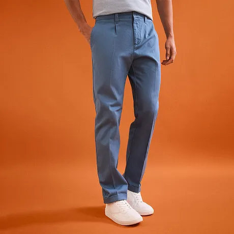 Pantalon chino décontracté en bleu clair et une paire de tennis blanches.