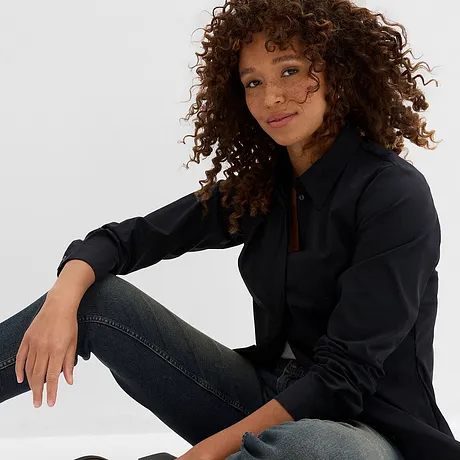 Une tenue décontractée composée d'une chemise noire et d'un jean foncé.