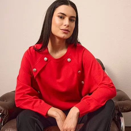 Un pull rouge lumineux avec des boutons extravagants.