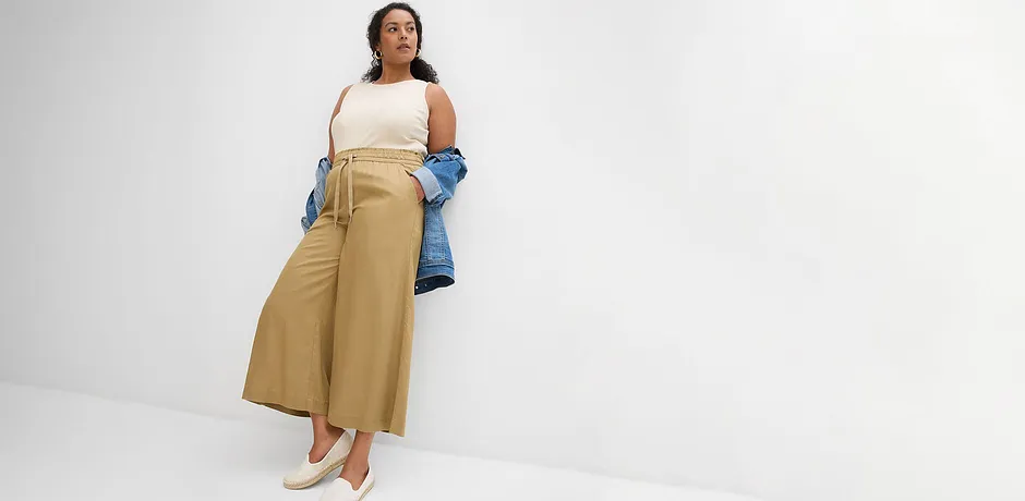 Look décontracté pour l'été : pantalon large beige, top blanc et veste en jean bleue relax.