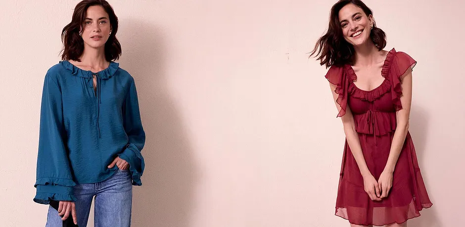 Blaue Jeansbluse mit Schnürung und fließendes rotes Kleid mit Rüschen.