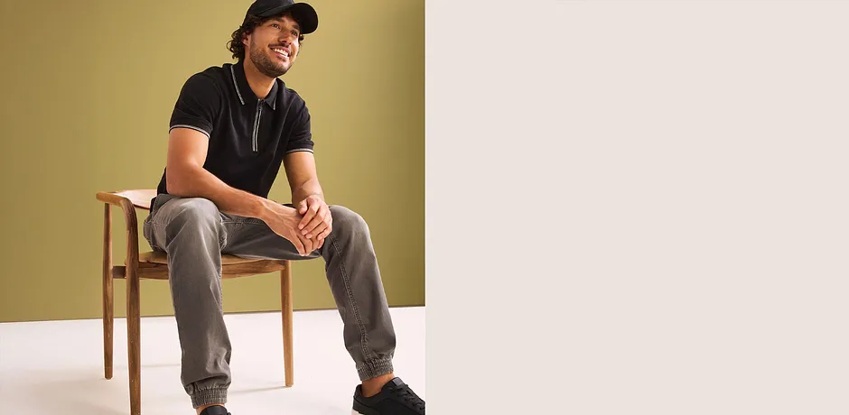 Jean jogging Regular Fit avec taille extensible associé à un polo noir.