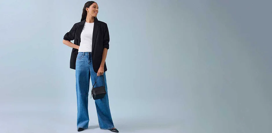 Veste noire, T-shirt blanc et jean large pour un style moderne.