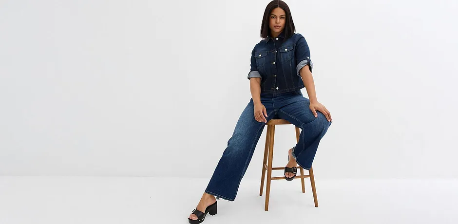Jean bleu foncé porté avec une chemise en jean.