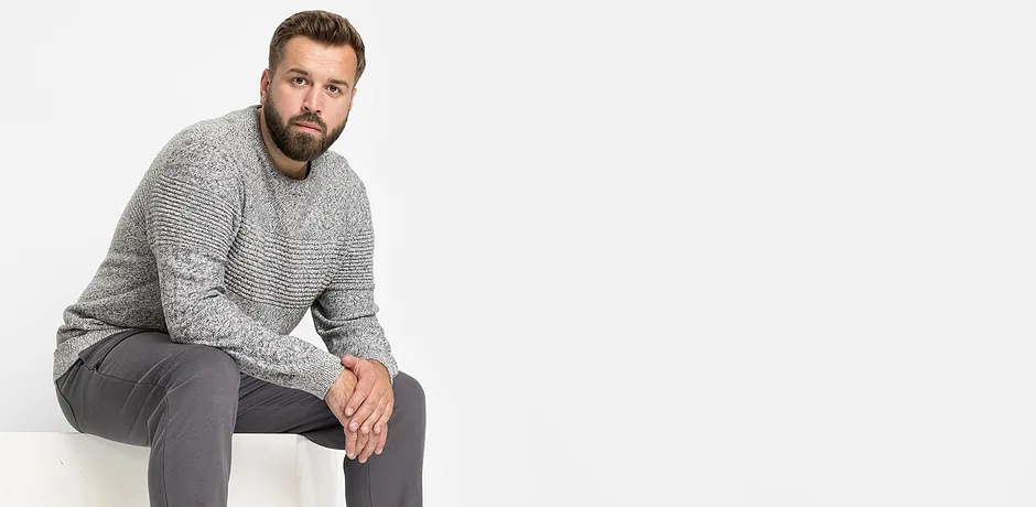 Pull en maille gris et pantalon gris pour une tenue décontractée.