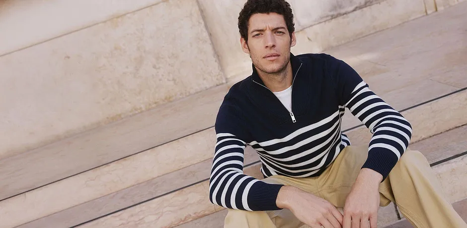 Pull bleu marine à rayures blanches.